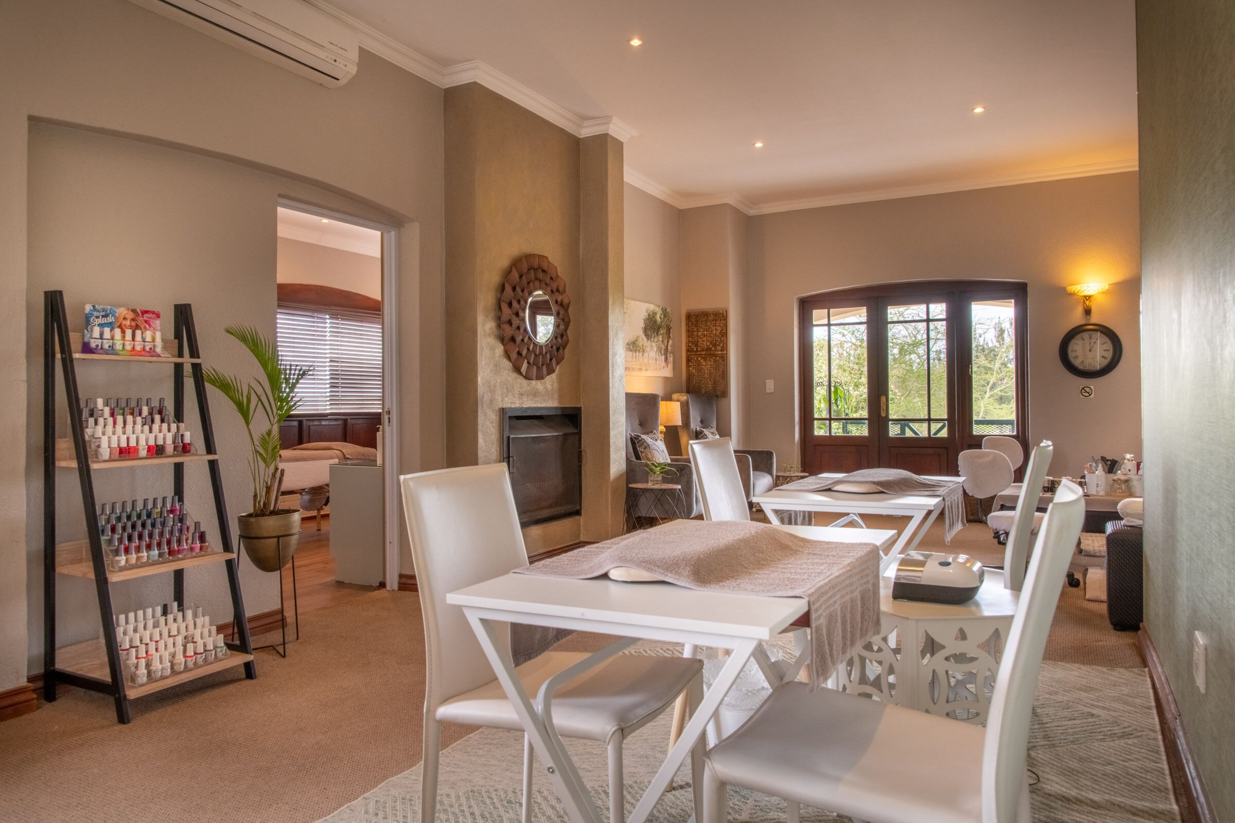 A hotel room with a dining area, a fireplace, and a large window with a view of trees.