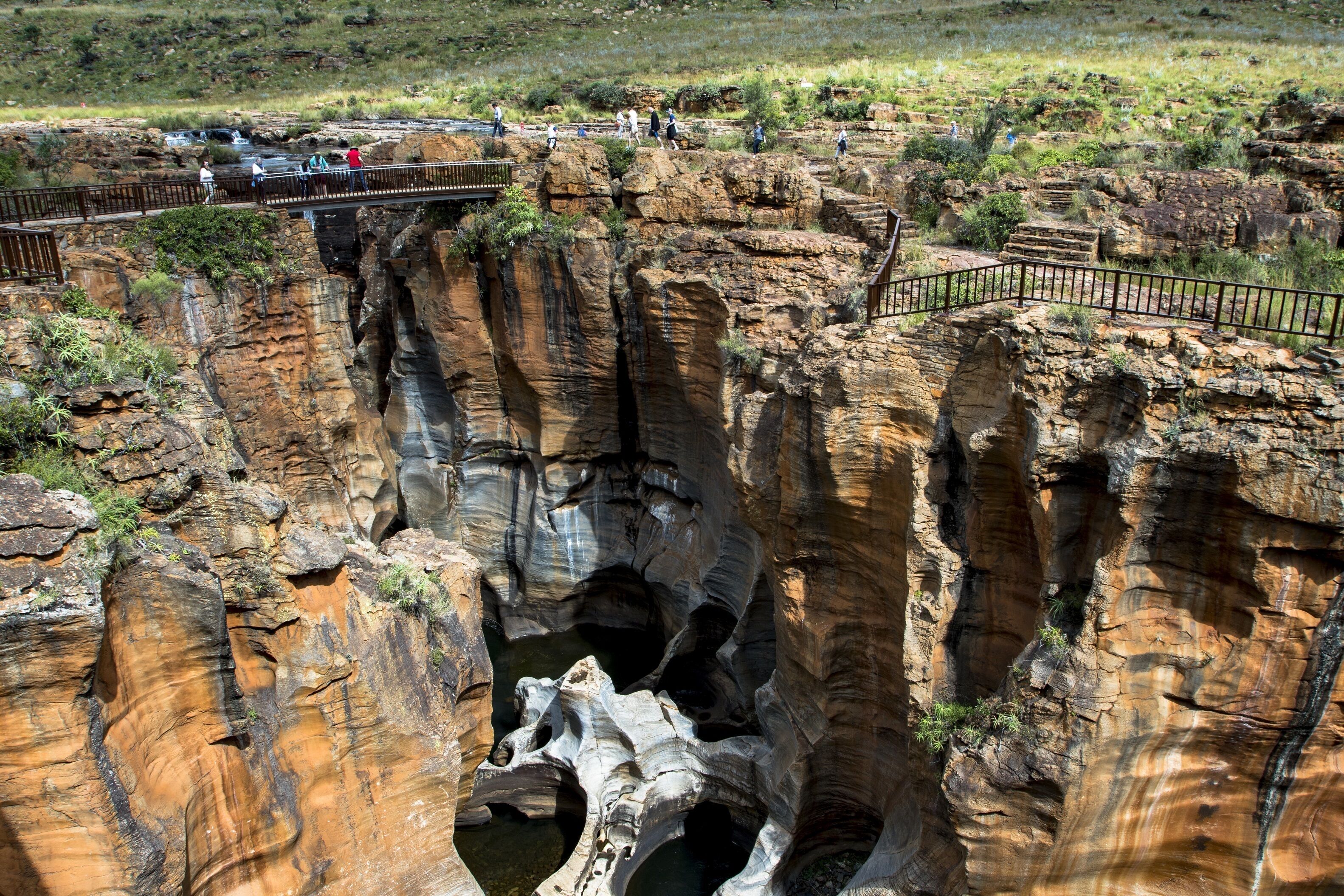 Un canyon rocheux doté d’une passerelle en bois et d’une rambarde en métal.