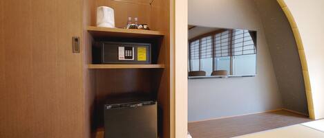 A compact room with a wooden cabinet, a microwave, and a small refrigerator.