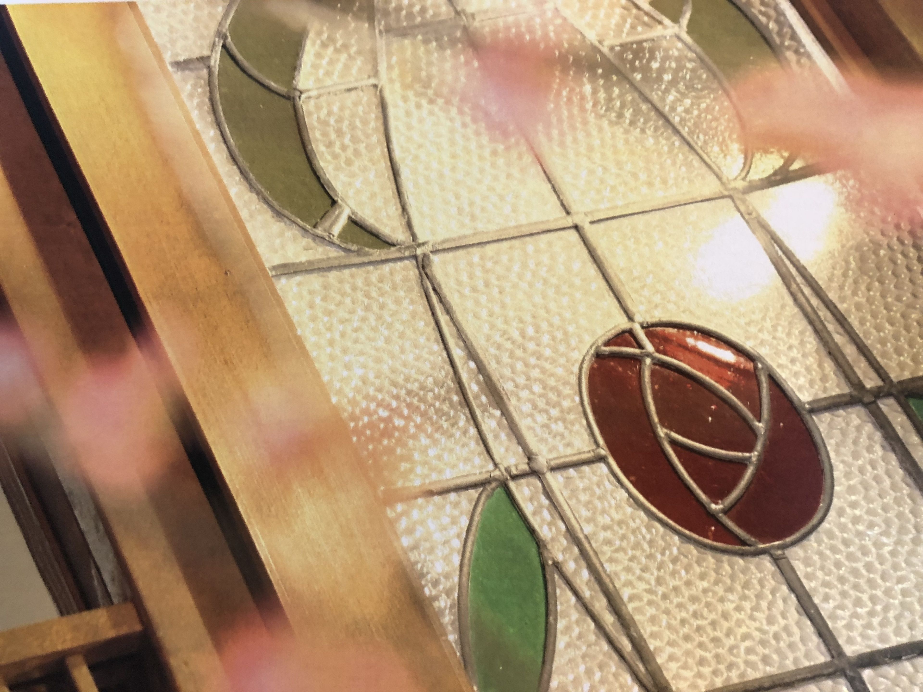 A stained glass window with geometric patterns and a central circular design.