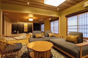 A traditional Japanese-style room with tatami flooring, a low wooden ceiling, and sliding shoji doors.