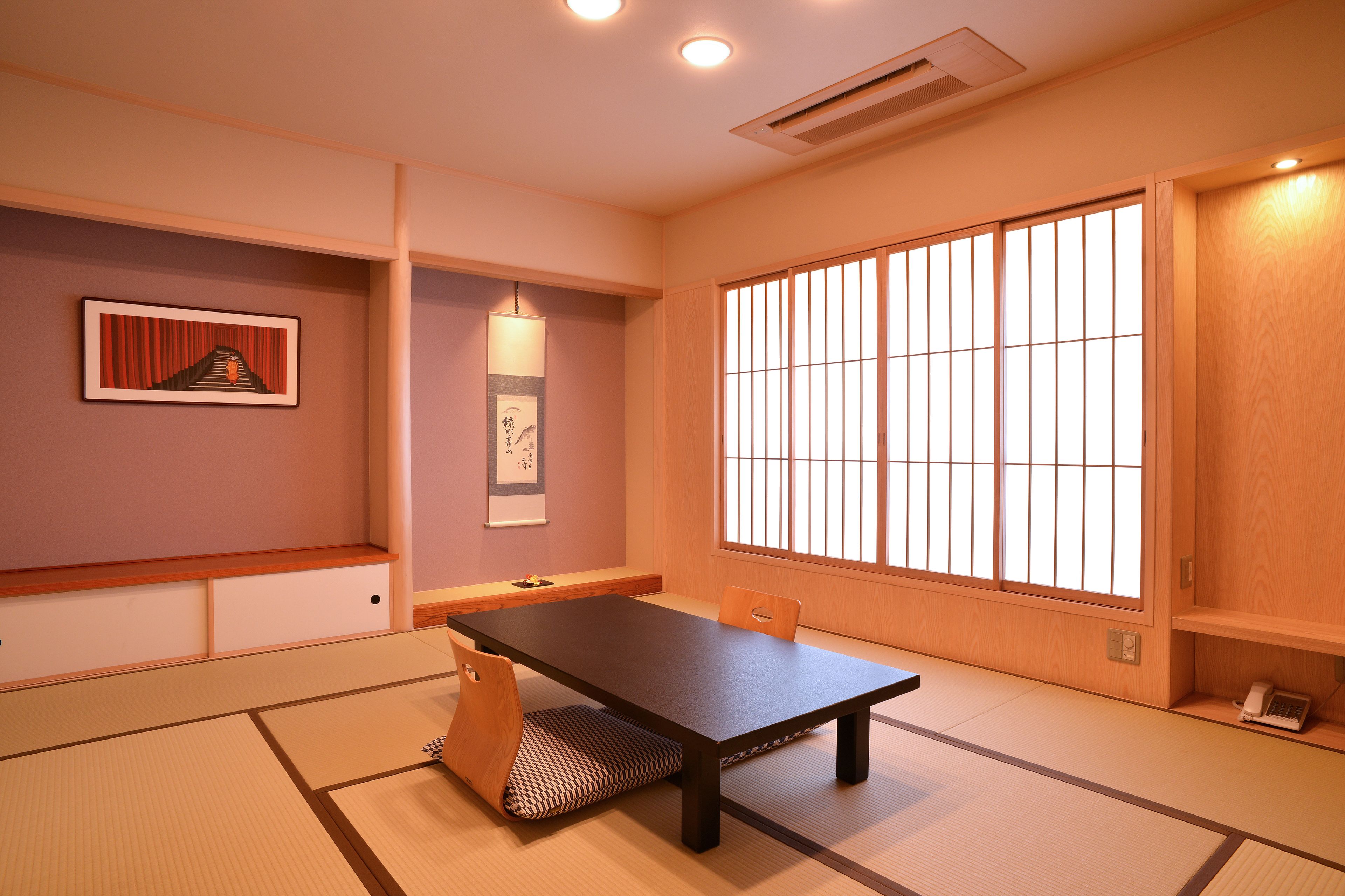 A traditional Japanese room with tatami flooring, a low table, and sliding doors.