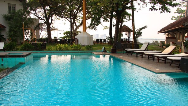 Una piscina con sillas de descanso y vistas al mar.