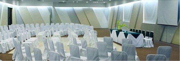 A conference room with rows of white-covered chairs and tables, arranged in a semi-circle. - Hotel Villa Florida Córdoba (Córdoba)