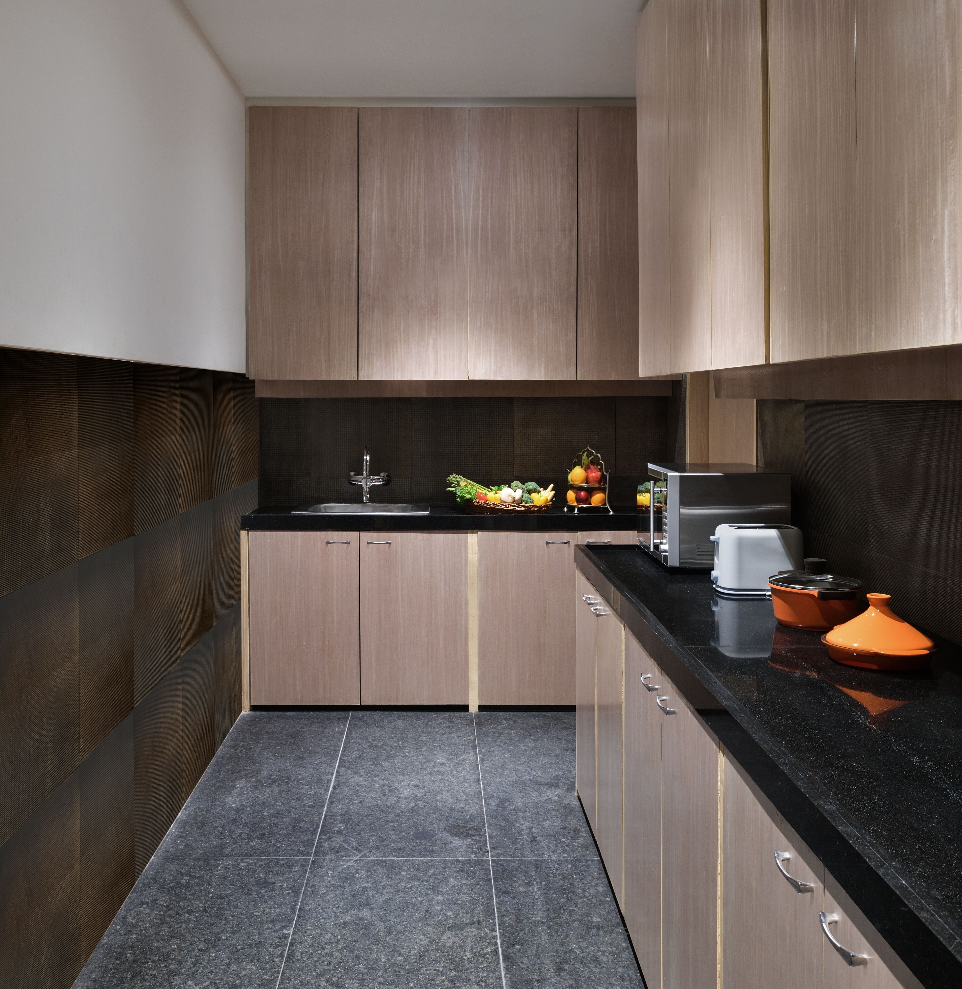 Una cocina moderna con armarios de madera, una encimera negra y un fregadero.