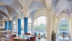 Un comedor amplio con techos altos y ventanas grandes, que ofrece vistas al exterior.