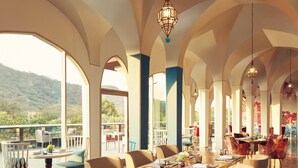 Un comedor amplio con techos altos, ventanas grandes y vistas al exterior.