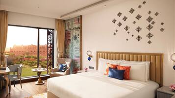 A hotel room with a large bed, a desk, and a view of a building through a window.