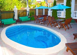 季节性开放的室外游泳池，池畔遮阳伞，日光浴躺椅