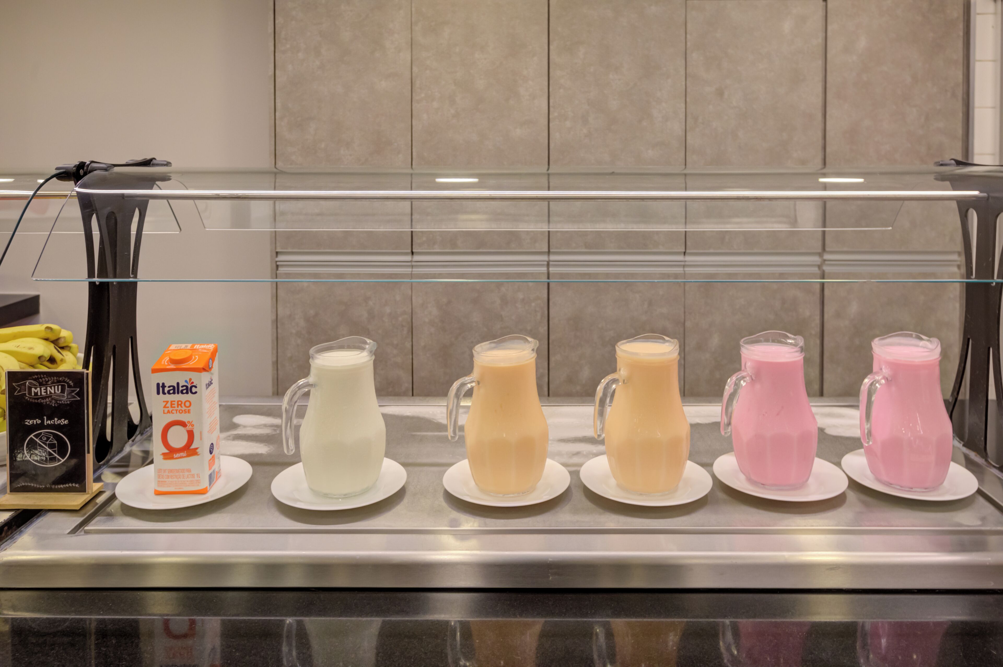 A beverage display with various milkshakes and a carton of milk.