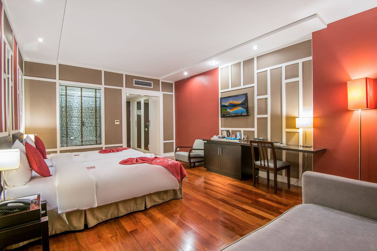 Une chambre d’hôtel moderne dotée d’un grand lit, d’un bureau et d’un coin salon.