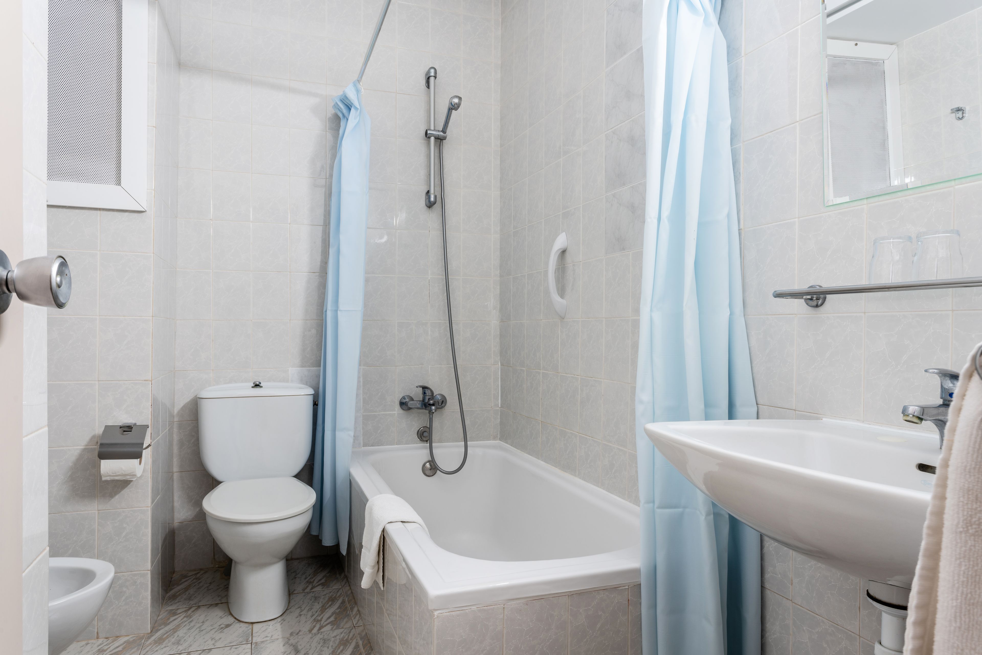 Un baño con inodoro, bañera y lavamanos.