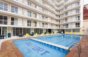 Un hôtel doté d’une grande piscine intérieure, de nombreux balcons et d’espaces extérieurs aménagés pour se détendre.