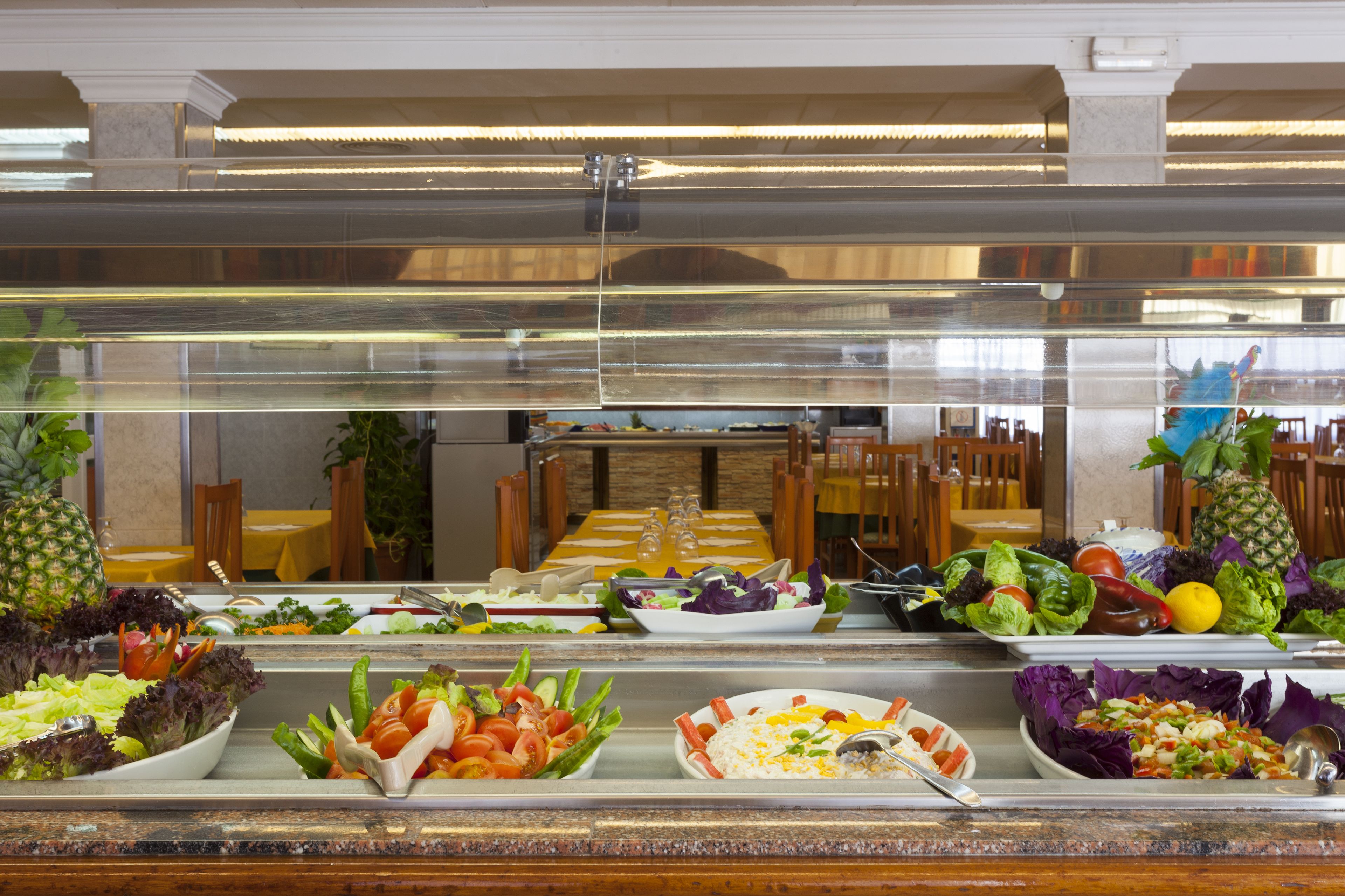 Un bufé con ensaladas, frutas y verduras variadas.