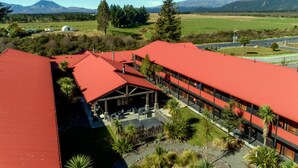 Un hotel con tejados rojos, un espacio al aire libre cubierto y vistas a una cadena montañosa.