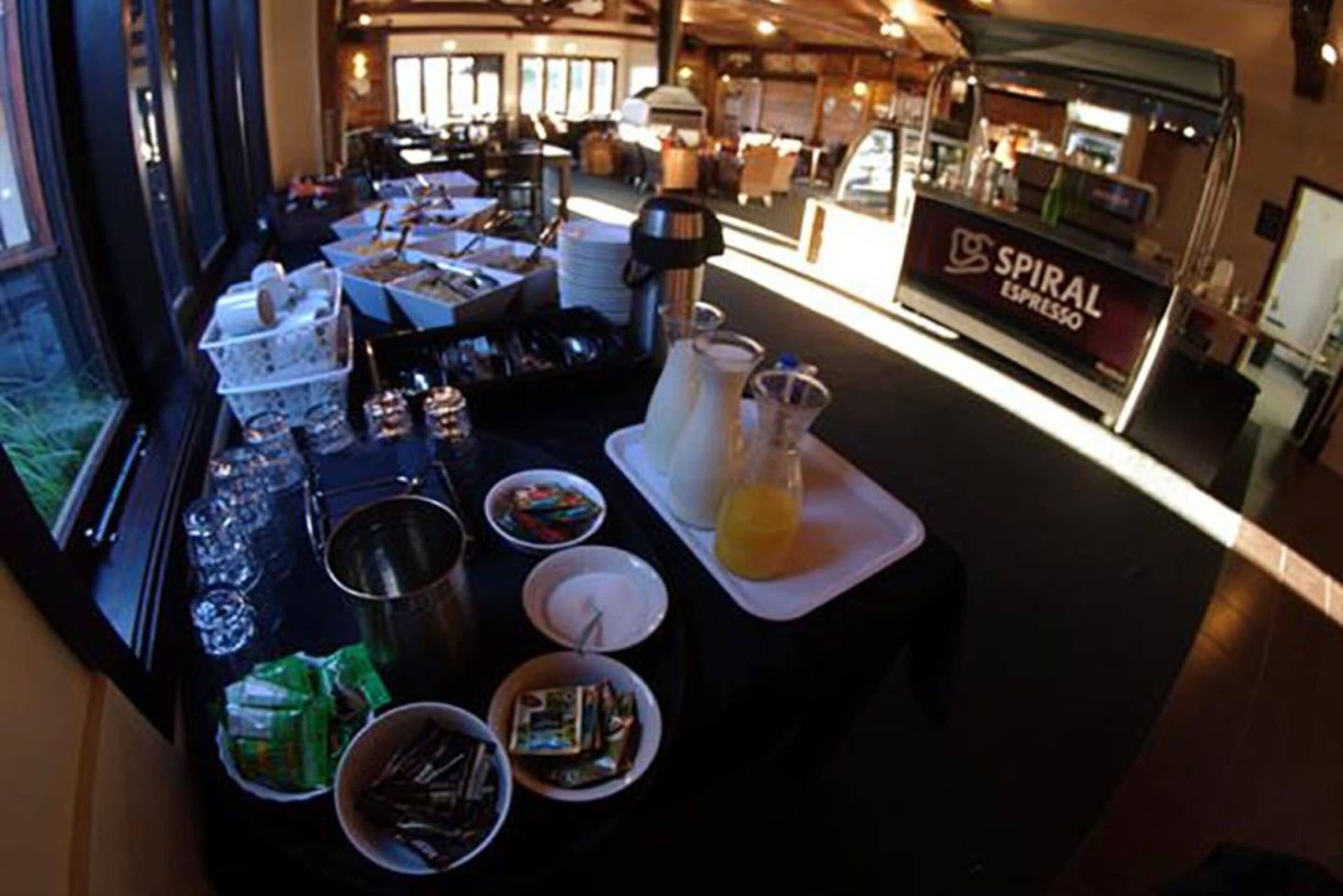 Een buffetopstelling met diverse gerechten en een koffiemachine met de tekst 'SPIRAL ESPRESSO'.