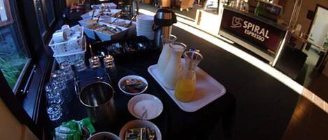 Een buffetopstelling met diverse gerechten en een koffiemachine met de tekst 'SPIRAL ESPRESSO'.