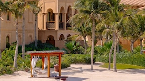A beachfront resort with a palm tree-lined walkway leading to a wooden gazebo. - One&Only The Palm (Dubai)