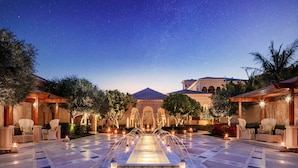 A courtyard with a central fountain, seating areas, and a starry night sky. - One&Only The Palm (Dubai)
