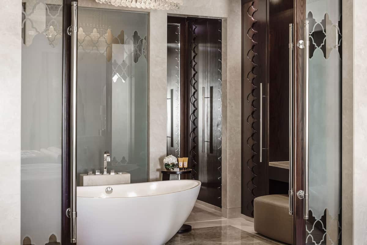 A modern bathroom with a freestanding bathtub, a vanity with a mirror, and a toilet.