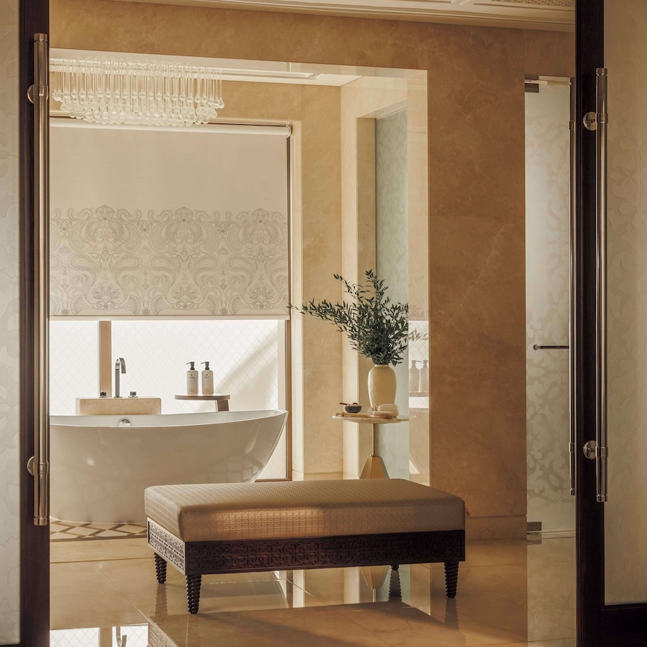 A modern bathroom with a freestanding bathtub, a vanity with a mirror, and a bench.