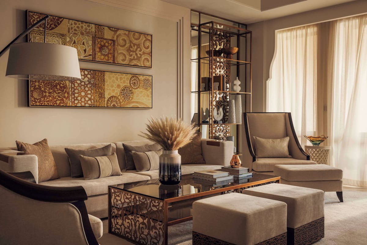 A modern living room with a sofa, ottomans, a coffee table, and a decorative cabinet.