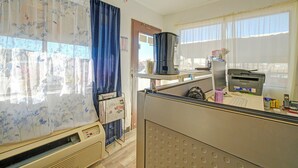 Un'area ufficio con termosifone, macchina del caffè, stampante e dispenser d'acqua.