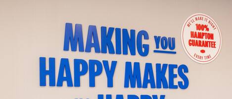 Een motiverende boodschap in blauwe letters op een structuurwand.