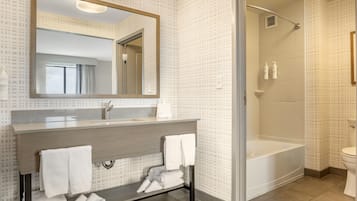 Un baño moderno con un espejo grande, un lavabo y una zona de ducha.