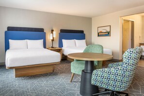 A hotel room with two beds, a small round table, a chair, a nightstand, and a painting on the wall. - Hampton Inn & Suites Cincinnati/Uptown-University Area (Cincinnati)