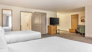 A hotel room with a bed, a television, a wardrobe, and a bathroom.