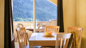 Un coin repas avec une table, des chaises et une assiette de fruits.