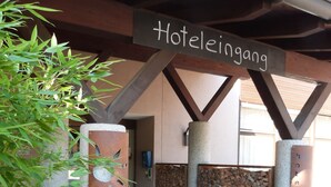 A hotel entrance with a sign reading "Hoteleingang" and a covered walkway. - Hotel Sportcenter Fünf Dörfer (Trimmis)