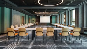A conference room with a long table, multiple chairs, and a projector screen. - Four Points by Sheraton Wroclaw (Wroclaw)