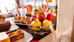 En morgenmadsbuffet med forskellige bagværk, frugt og brød.