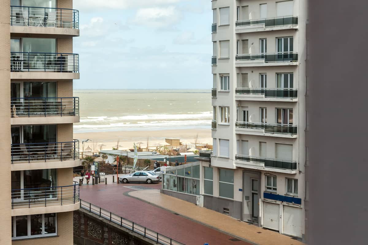 Ein mehrstöckiges Gebäude mit Balkonen mit Blick auf einen Strand.