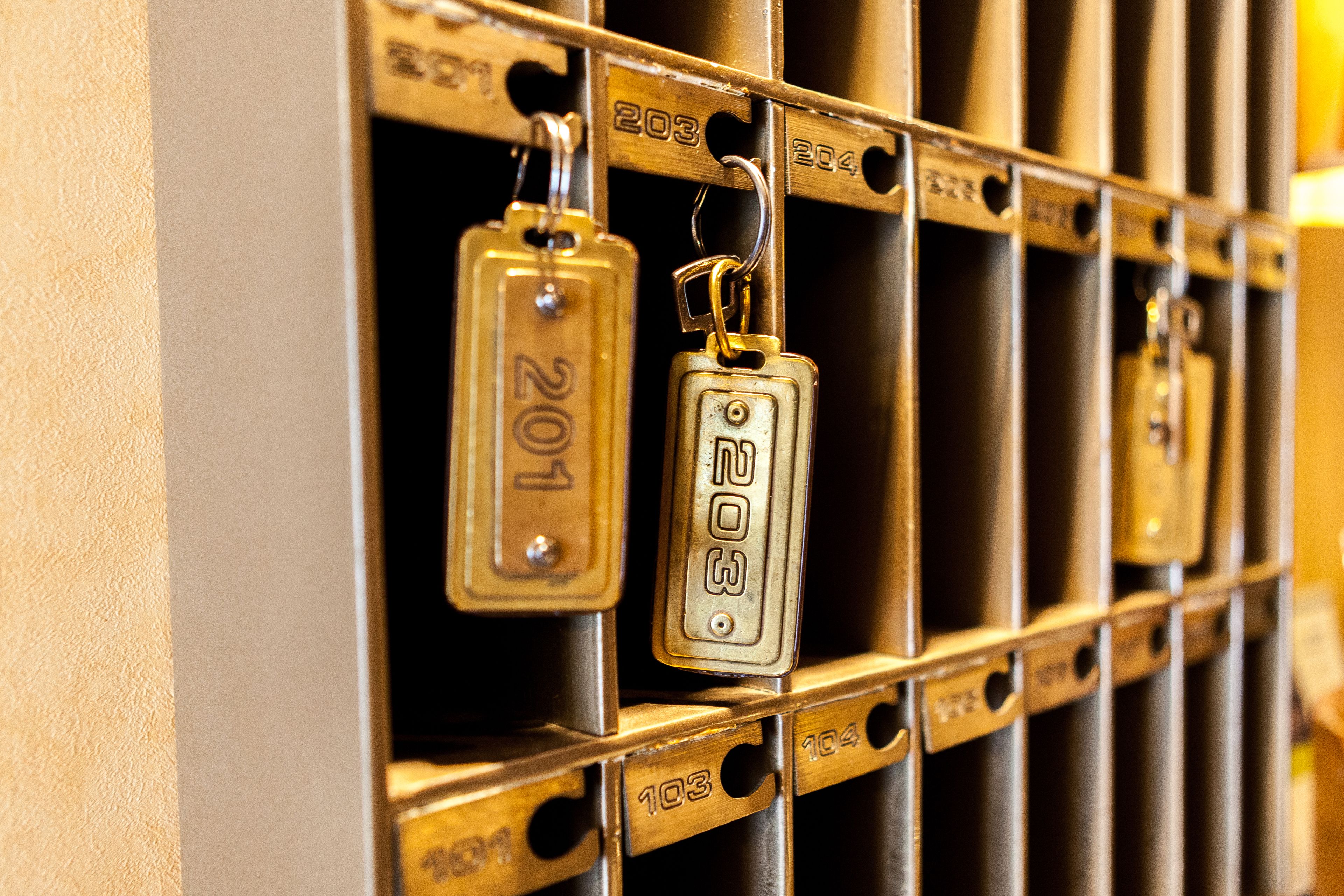 A close-up of a metal rack with numbered metal tags, likely used for room identification or inventory purposes.