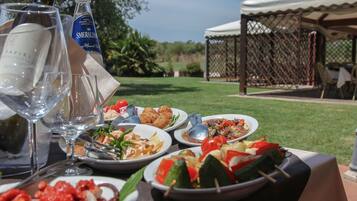 A table set with various dishes and drinks, a bottle of water, and a wine glass.