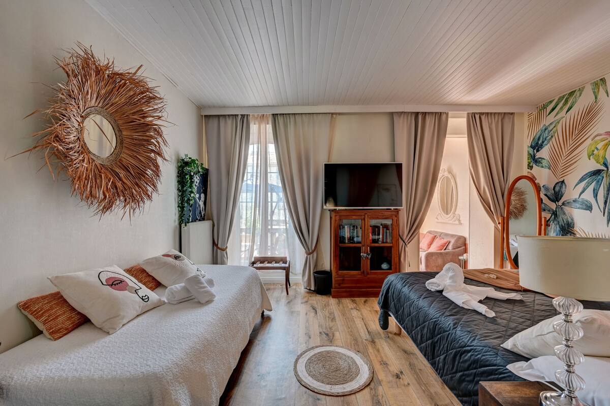 A well-lit room with a bed, a TV, and a wooden cabinet.