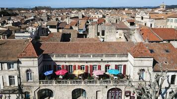 Un bâtiment historique doté d’un balcon, de murs en pierre et d’un toit recouvert de tuiles rouges.