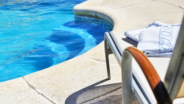 Ein Poolbereich mit Liegestuhl und Handtuch.