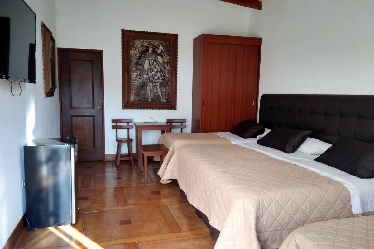 Un dormitorio con cama, escritorio y silla.