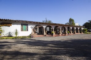 A building with a white facade, multiple arches, and a gravel driveway. - Casa Hacienda Nasca Oasis (Nazca)