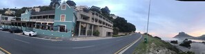 Enjoy ocean views from the balcony of this coastal establishment, overlooking the street and distant mountain peak.