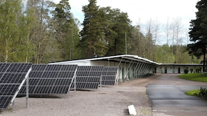 Un edificio con paneles solares y un espacio exterior cubierto.