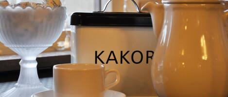 A tea set with a cup and saucer, a sugar bowl, and a teapot with a lid.