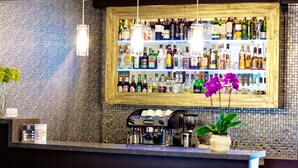 Uma área de bar com prateleiras de garrafas de bebidas, uma máquina de café e um vaso de planta.