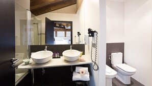 Un baño moderno con dos lavamanos, inodoro y secador de pelo.