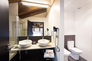 A modern bathroom with two sinks, a toilet, and a hairdryer. - Hotel Dolarea (Beasain)