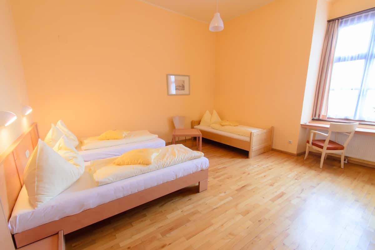 Een kamer met twee bedden, een bureau en een stoel.